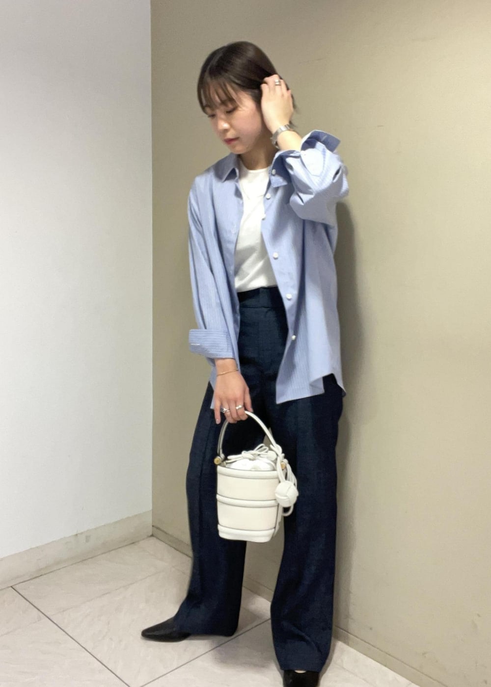 ホワイト系のハンドバッグ、ブルー系のデニムパンツ、ブルー系のシャツ/ブラウスを着用したレディースの春コーディネートの10枚目の写真