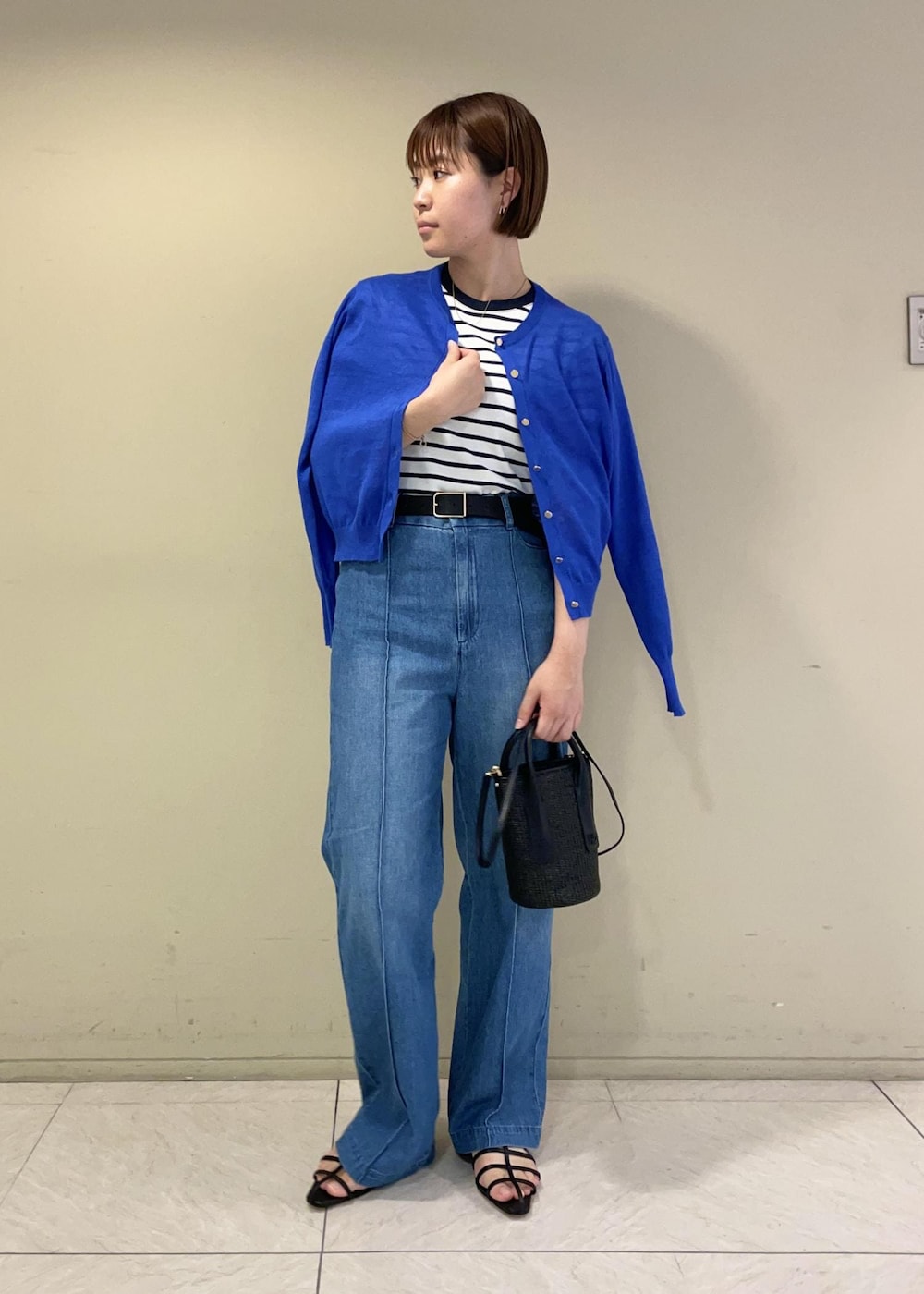 ブルー系のカーディガン/ボレロ、ブラック系のサンダル、ブラック系のハンドバッグを着用したレディースの夏コーディネートの2枚目の写真