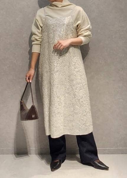 ブルー系のデニムパンツ、グレー系のハンドバッグ、ホワイト系のワンピースを着用したレディースの冬コーディネートの3枚目の写真