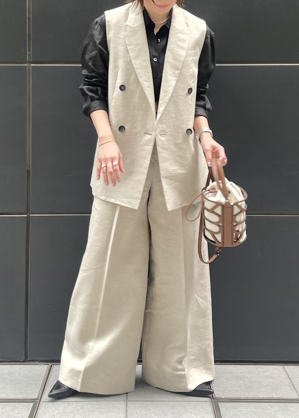 ブラック系のパンプス、ブラック系のシャツ/ブラウス、ベージュ系のベストを着用したレディースの春コーディネートの3枚目の写真