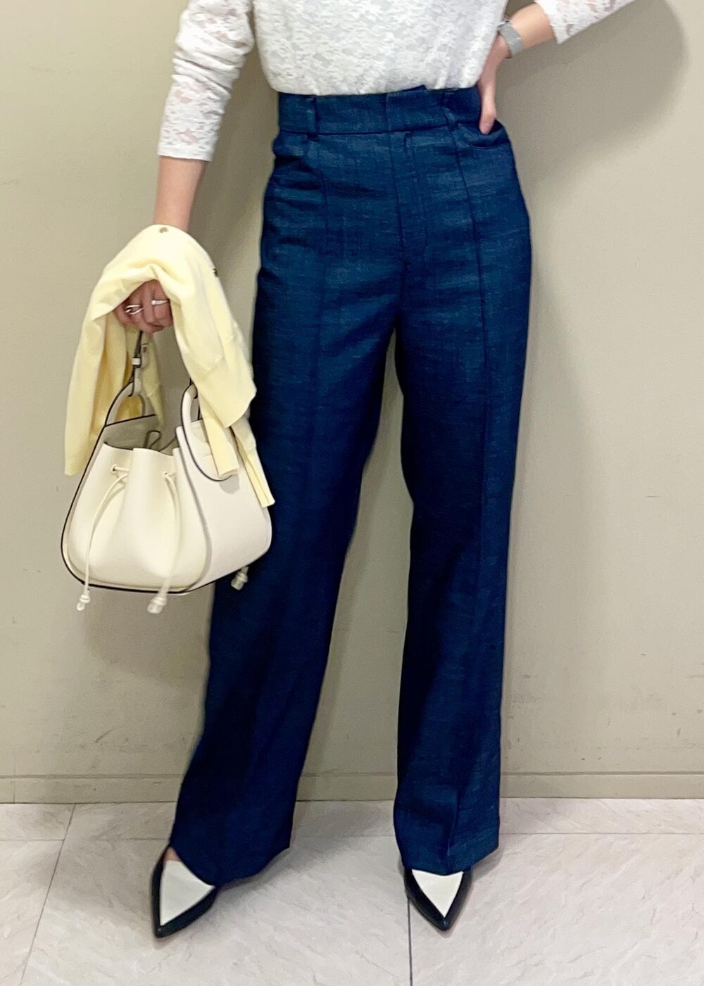 ブラック系のパンプス、イエロー系のカーディガン/ボレロ、ホワイト系のTシャツ/カットソーを着用したレディースの春コーディネートの6枚目の写真