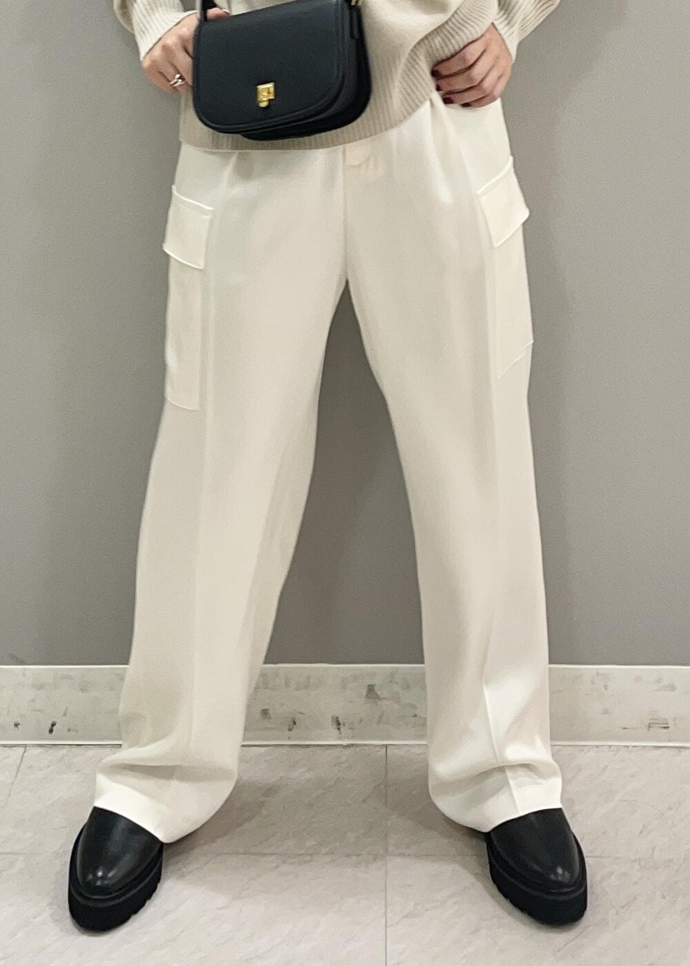 ブラック系のショルダーバッグ、ブラック系のブーツ、ベージュ系のニット/セーターを着用したレディースの秋コーディネートの8枚目の写真