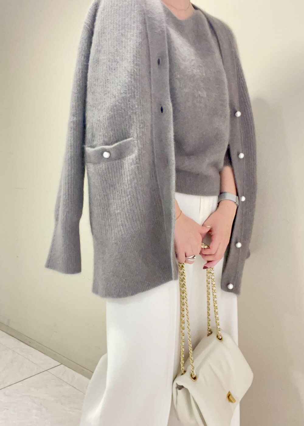 ホワイト系のハンドバッグ、ブラウン系のカーディガン/ボレロ、ブラウン系のニット/セーターを着用したレディースの秋コーディネートの5枚目の写真