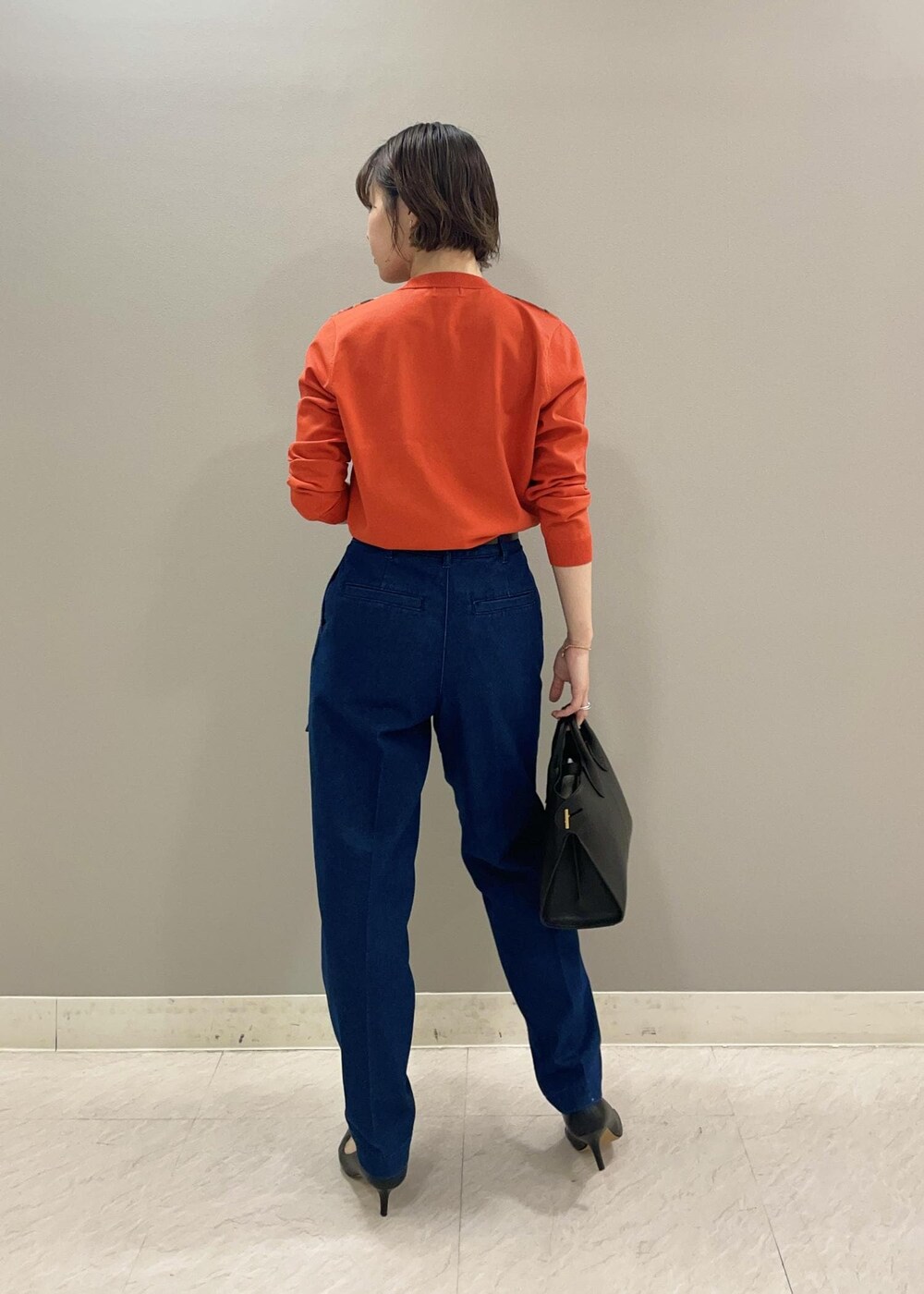 オレンジ系のカーディガン/ボレロ、ブルー系のデニムパンツ、ブラック系のパンプスを着用したレディースの夏コーディネートの3枚目の写真