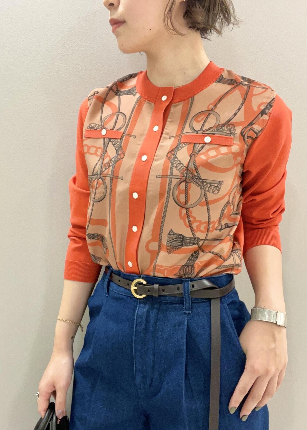 オレンジ系のカーディガン/ボレロ、ブルー系のデニムパンツ、ブラック系のパンプスを着用したレディースの夏コーディネートの5枚目の写真