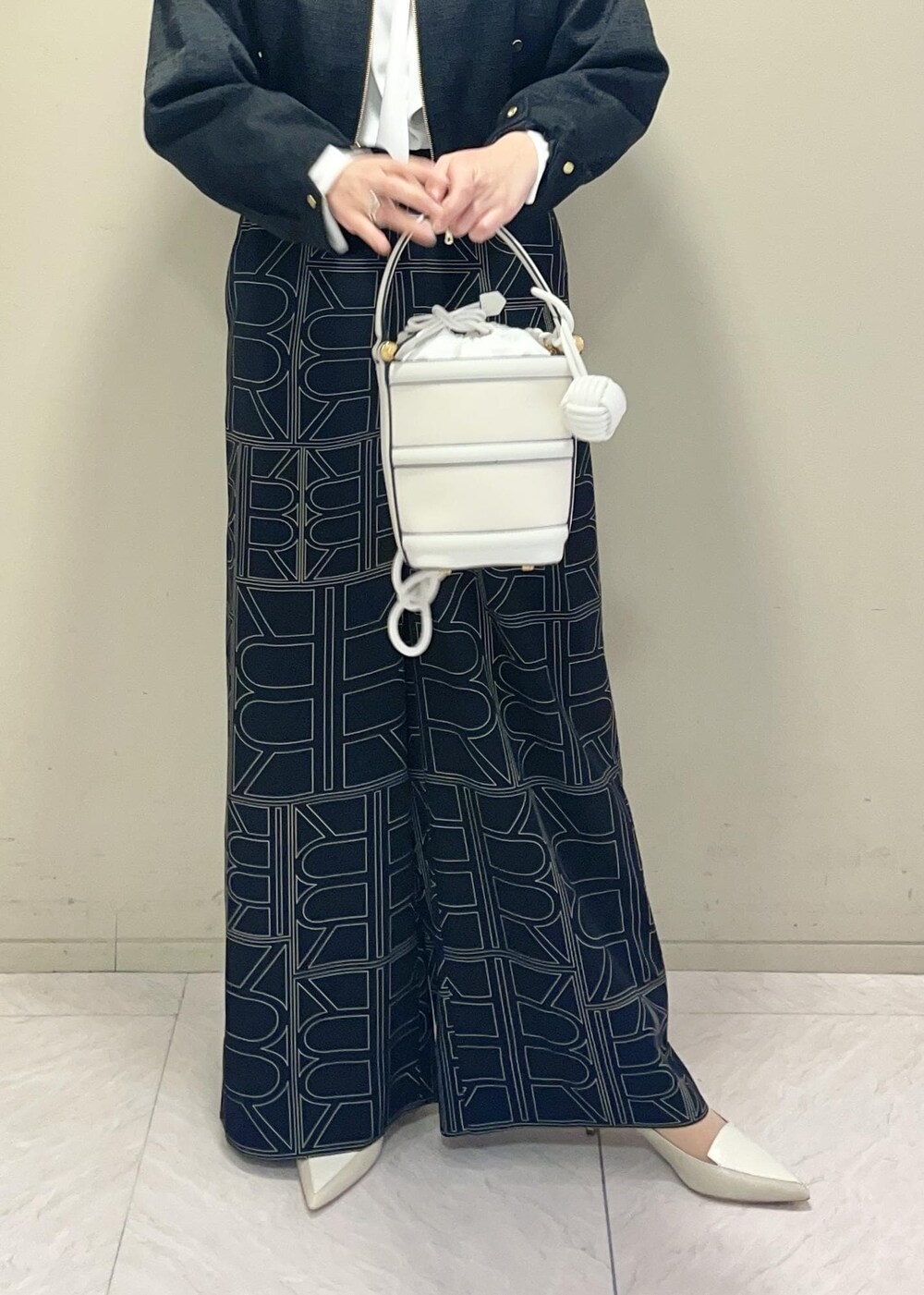 ホワイト系のハンドバッグ、ブラック系のその他パンツ、ブラック系のブルゾンを着用したレディースの冬コーディネートの8枚目の写真