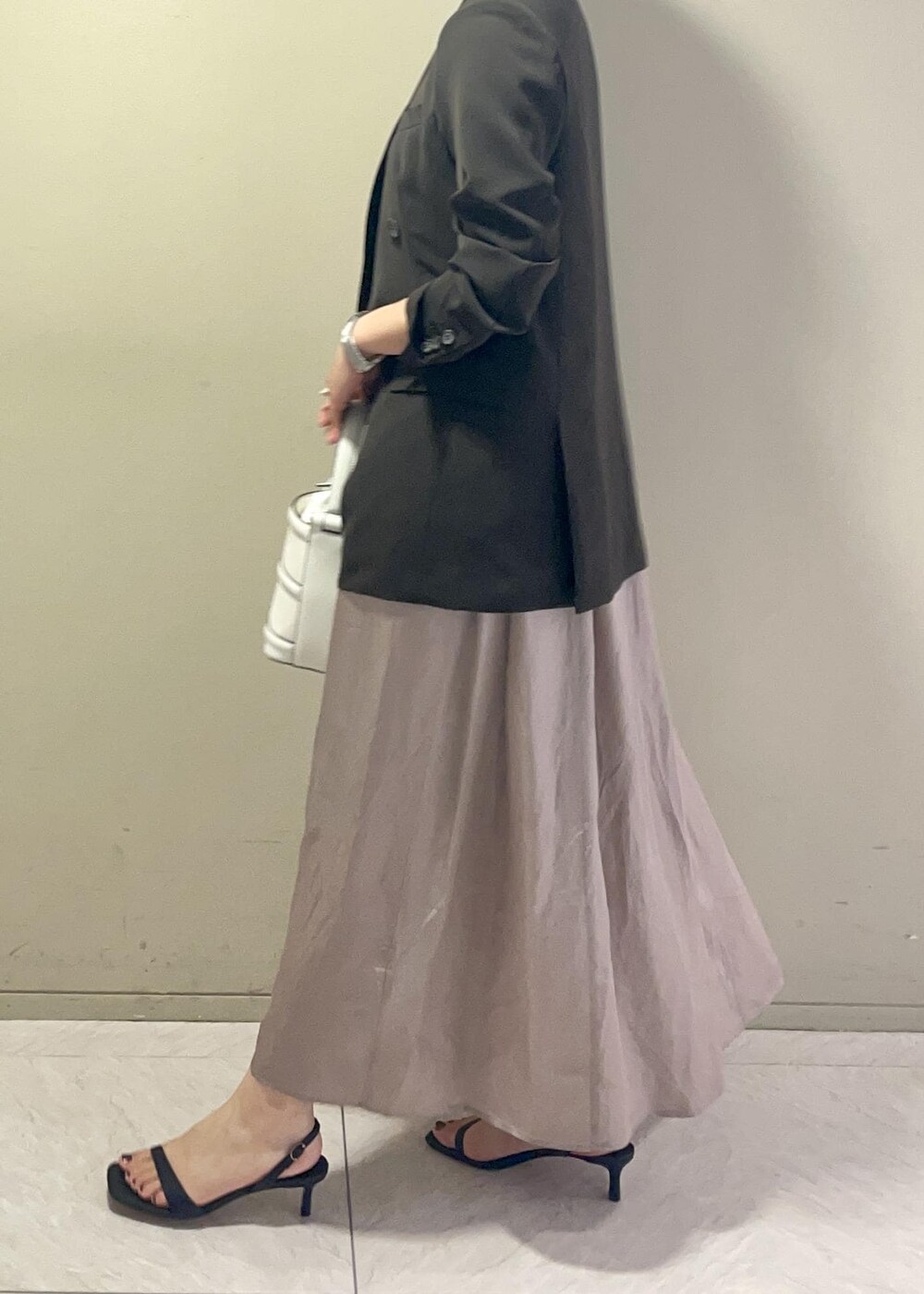 ホワイト系のハンドバッグ、ブラック系のサンダル、ブラウン系のテーラードジャケットを着用したレディースの春コーディネートの4枚目の写真