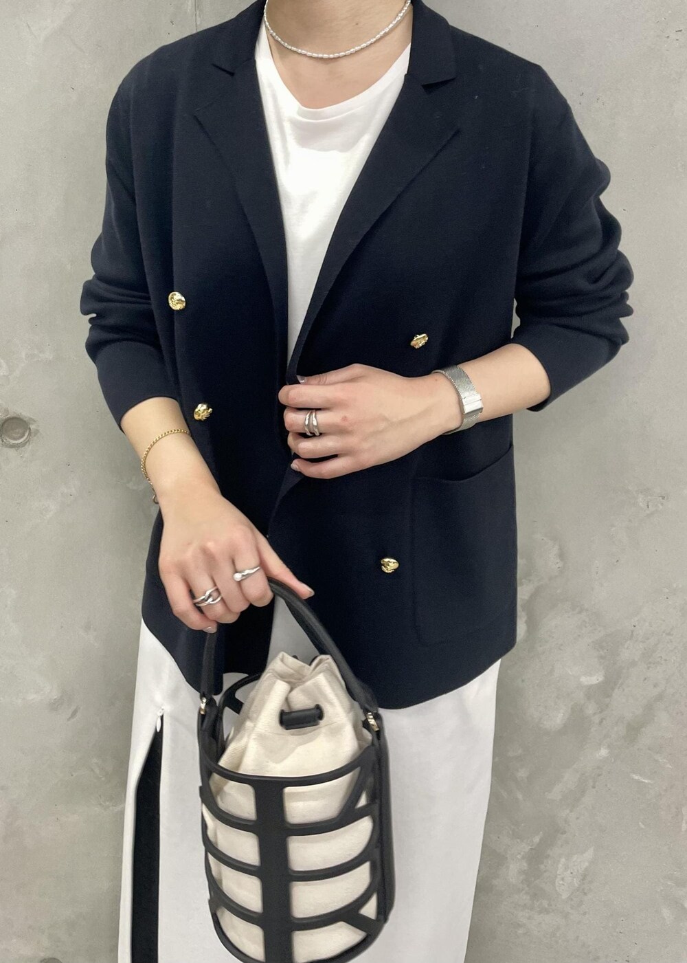 ブラック系のハンドバッグ、ブルー系のテーラードジャケット、ブラック系のその他パンツを着用したレディースの春コーディネートの7枚目の写真
