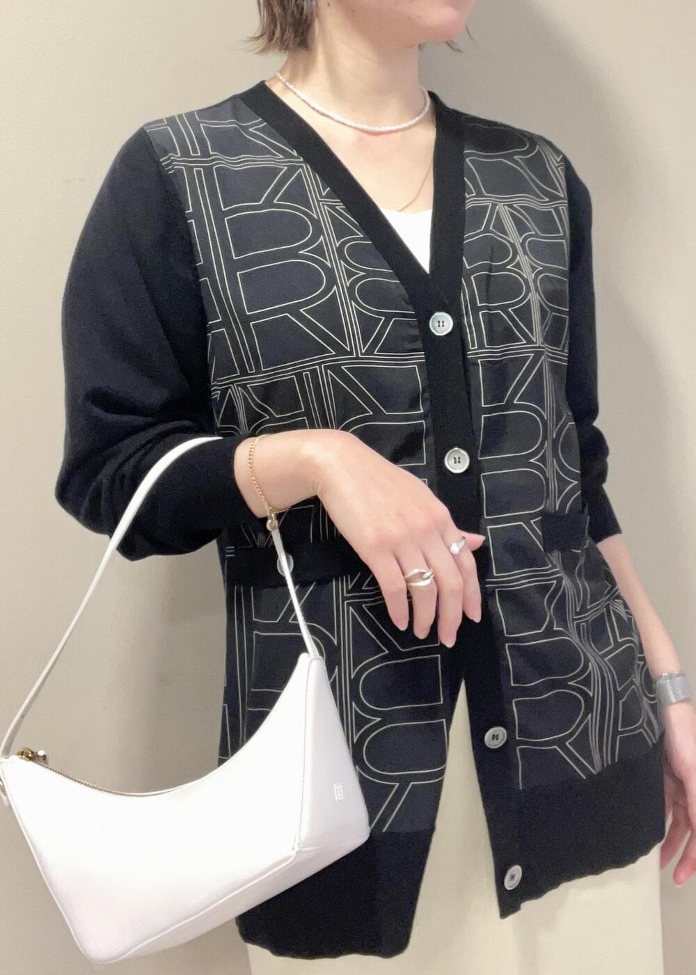 ブラック系のパンプス、ベージュ系のスカート、ブラック系のカーディガン/ボレロを着用したレディースの冬コーディネートの7枚目の写真