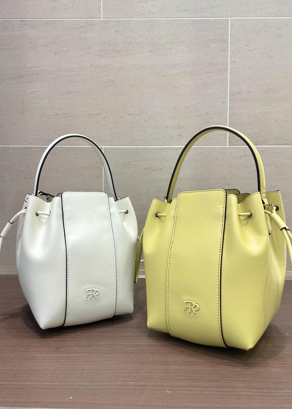 ベージュ系のハンドバッグ、ホワイト系のTシャツ/カットソー、ブラック系のスカートを着用したレディースの夏コーディネートの7枚目の写真