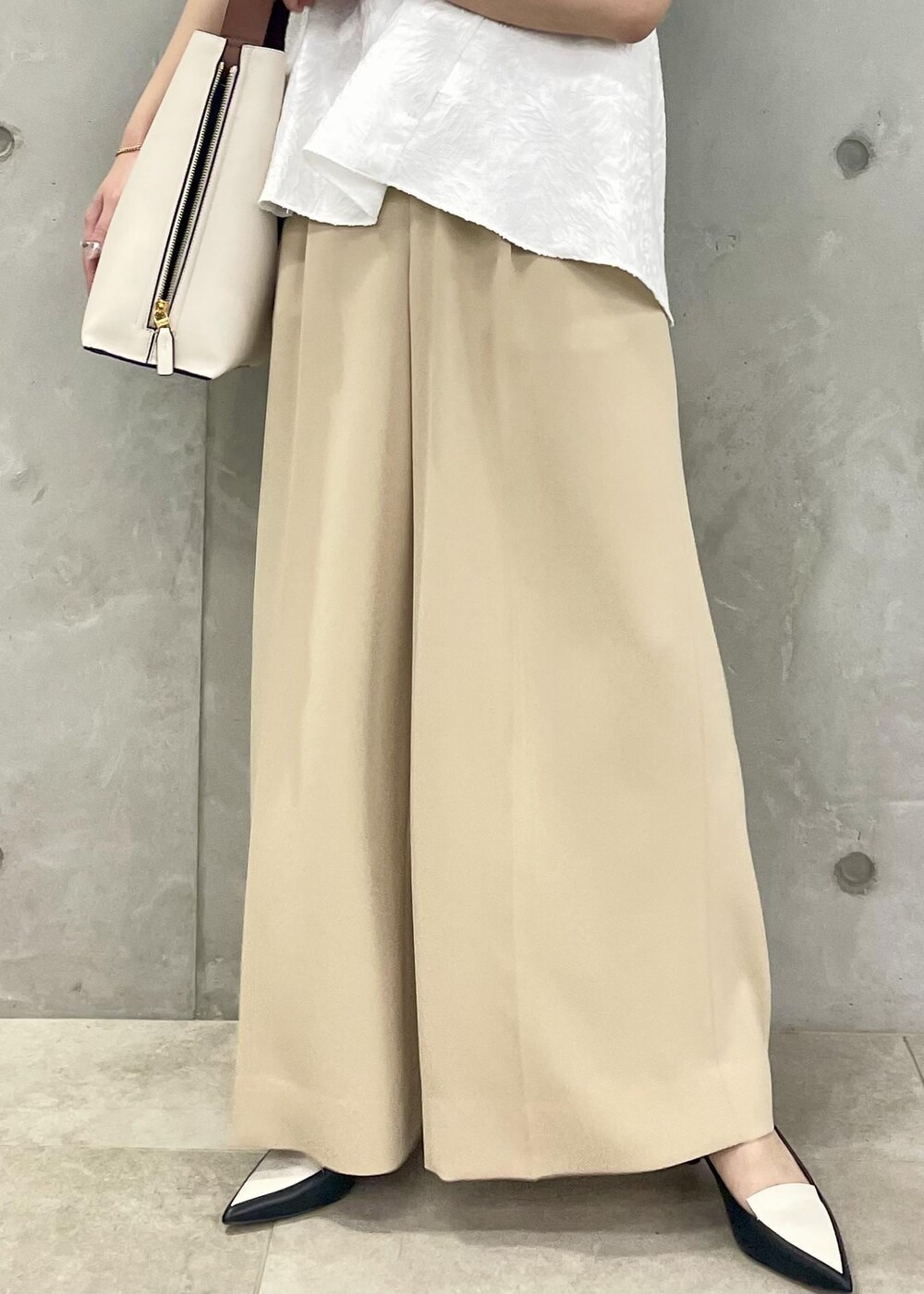 ホワイト系のショルダーバッグ、ブラック系のパンプス、ホワイト系のシャツ/ブラウスを着用したレディースの春コーディネートの7枚目の写真