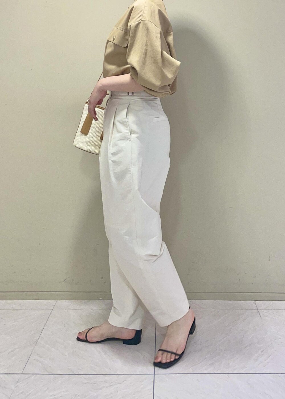 ブラック系のサンダル、ベージュ系のハンドバッグ、ホワイト系のその他パンツを着用したレディースの夏コーディネートの4枚目の写真
