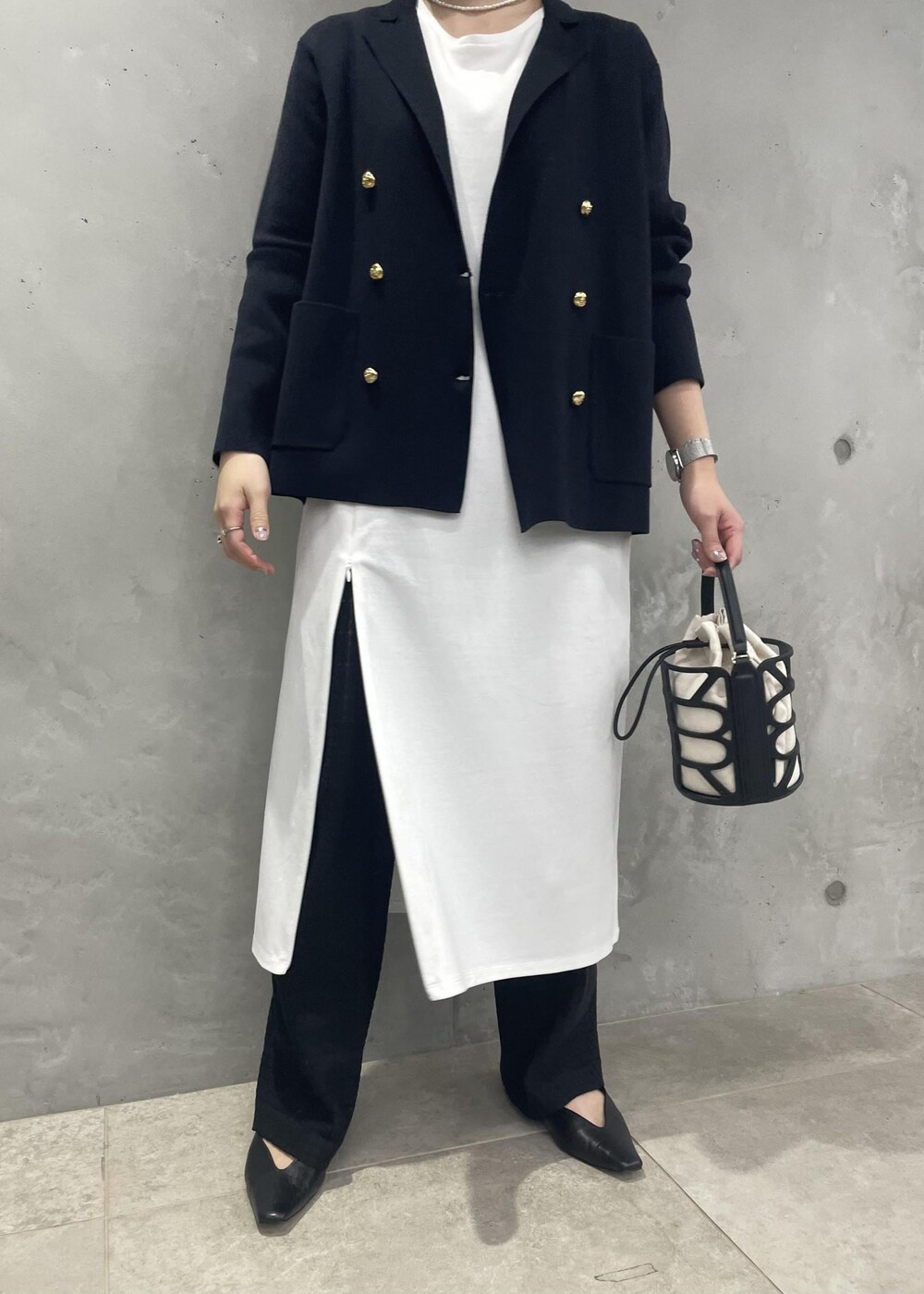 ブラック系のハンドバッグ、ブルー系のテーラードジャケット、ブラック系のその他パンツを着用したレディースの春コーディネートの6枚目の写真