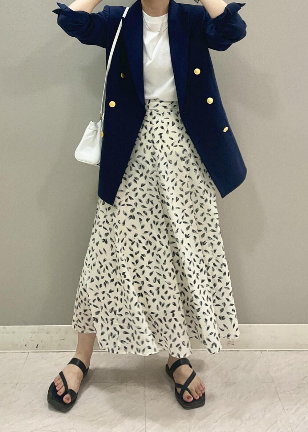 ホワイト系のハンドバッグ、ホワイト系のTシャツ/カットソー、ブルー系のテーラードジャケットを着用したレディースの夏コーディネートの3枚目の写真