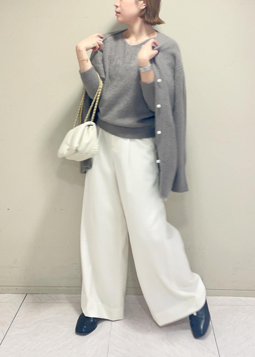 ホワイト系のハンドバッグ、ブラウン系のカーディガン/ボレロ、ブラウン系のニット/セーターを着用したレディースの秋コーディネートの3枚目の写真