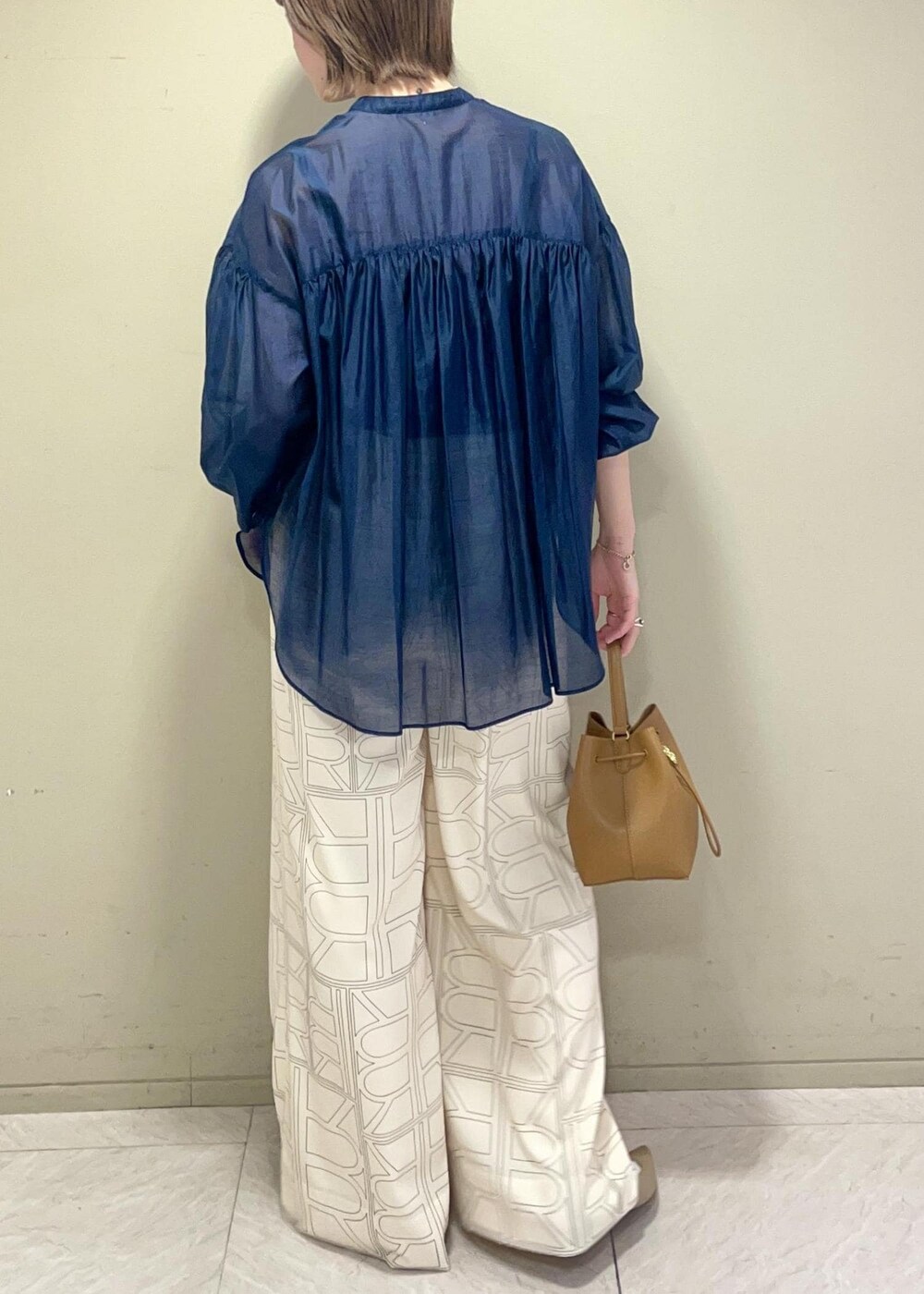 イエロー系のハンドバッグ、ホワイト系のその他パンツ、ブルー系のシャツ/ブラウスを着用したレディースの冬コーディネートの5枚目の写真