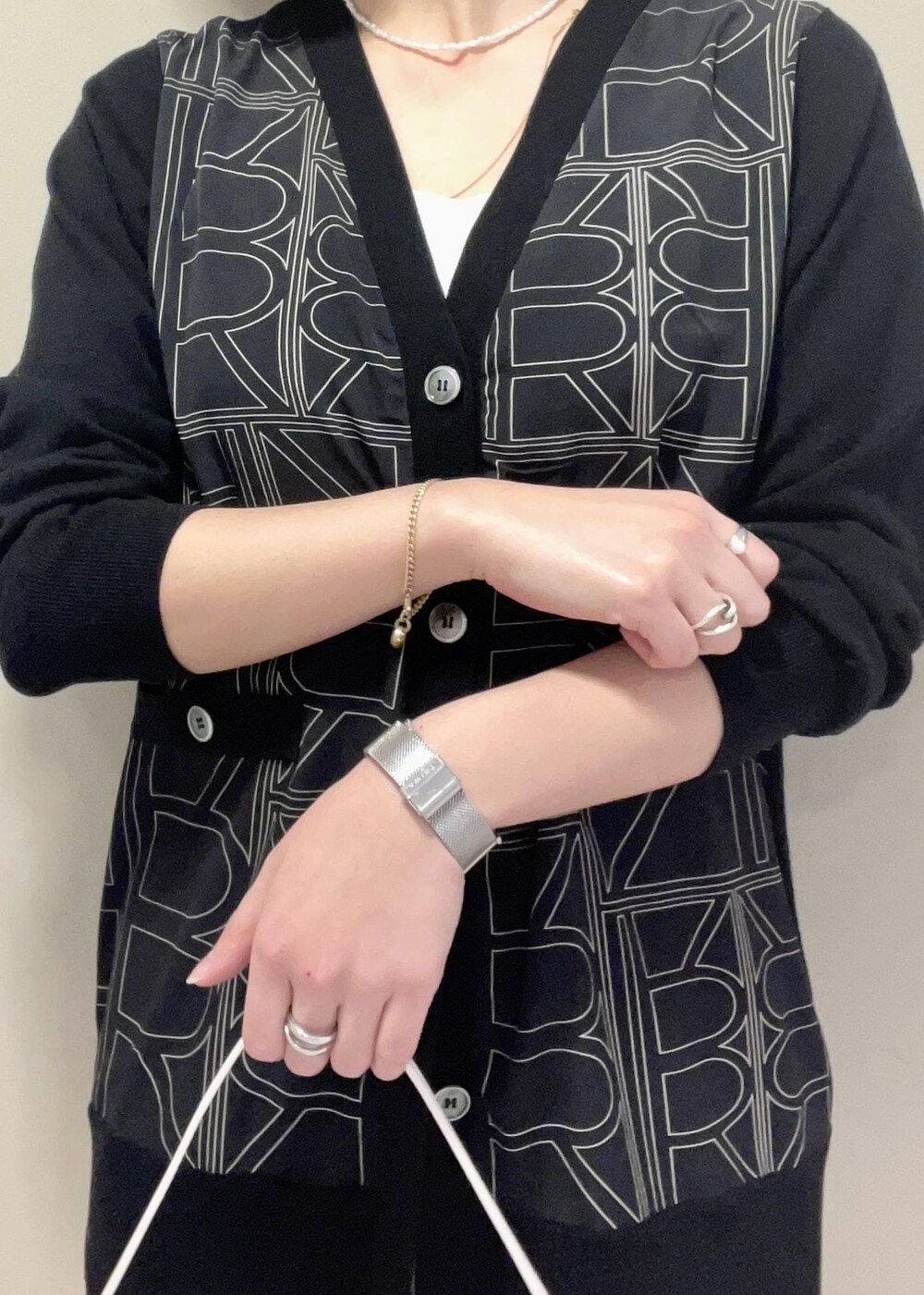 ブラック系のパンプス、ベージュ系のスカート、ブラック系のカーディガン/ボレロを着用したレディースの冬コーディネートの8枚目の写真