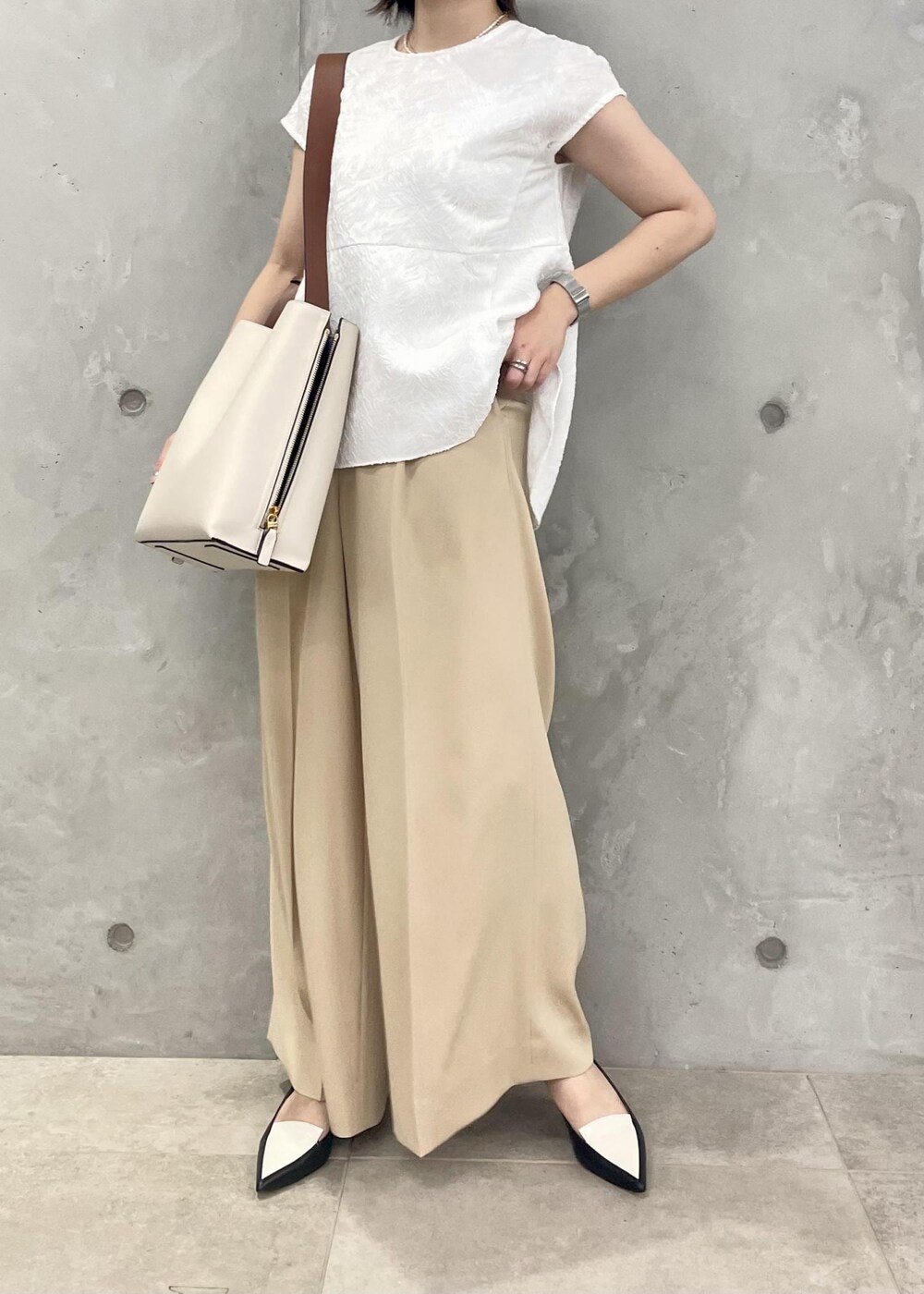 ホワイト系のショルダーバッグ、ブラック系のパンプス、ホワイト系のシャツ/ブラウスを着用したレディースの春コーディネートの4枚目の写真