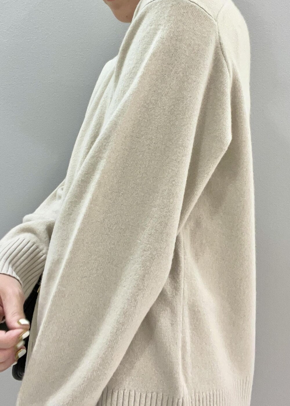 ブラック系のショルダーバッグ、ブラック系のブーツ、ベージュ系のニット/セーターを着用したレディースの秋コーディネートの9枚目の写真