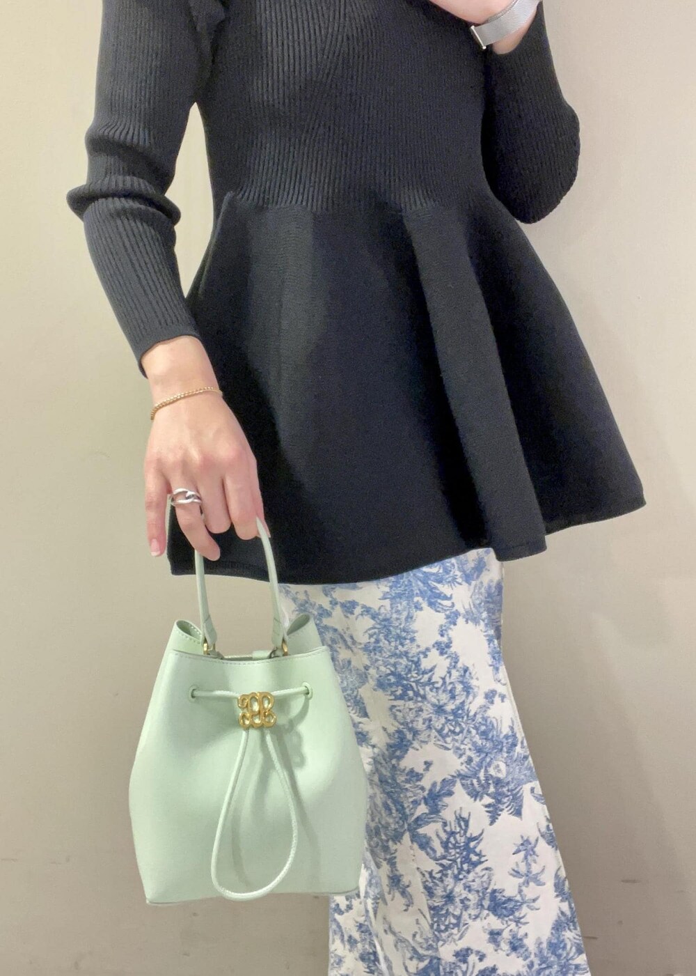 グリーン系のハンドバッグ、ブラック系のニット/セーター、ブルー系のその他パンツを着用したレディースの冬コーディネートの7枚目の写真