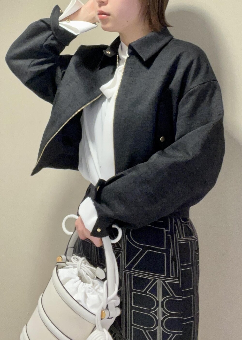 ホワイト系のハンドバッグ、ブラック系のその他パンツ、ブラック系のブルゾンを着用したレディースの冬コーディネートの7枚目の写真