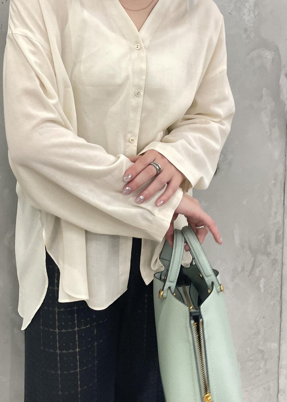 グリーン系のハンドバッグ、ベージュ系のパンプス、ブラック系のその他パンツを着用したレディースの春コーディネートの8枚目の写真