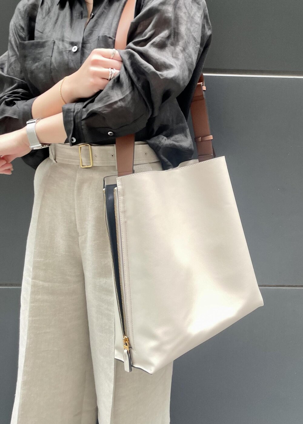 ブラック系のパンプス、ホワイト系のショルダーバッグ、ベージュ系のその他パンツを着用したレディースの春コーディネートの4枚目の写真