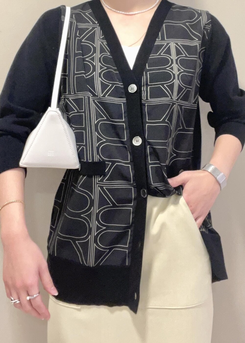 ブラック系のパンプス、ベージュ系のスカート、ブラック系のカーディガン/ボレロを着用したレディースの冬コーディネートの9枚目の写真