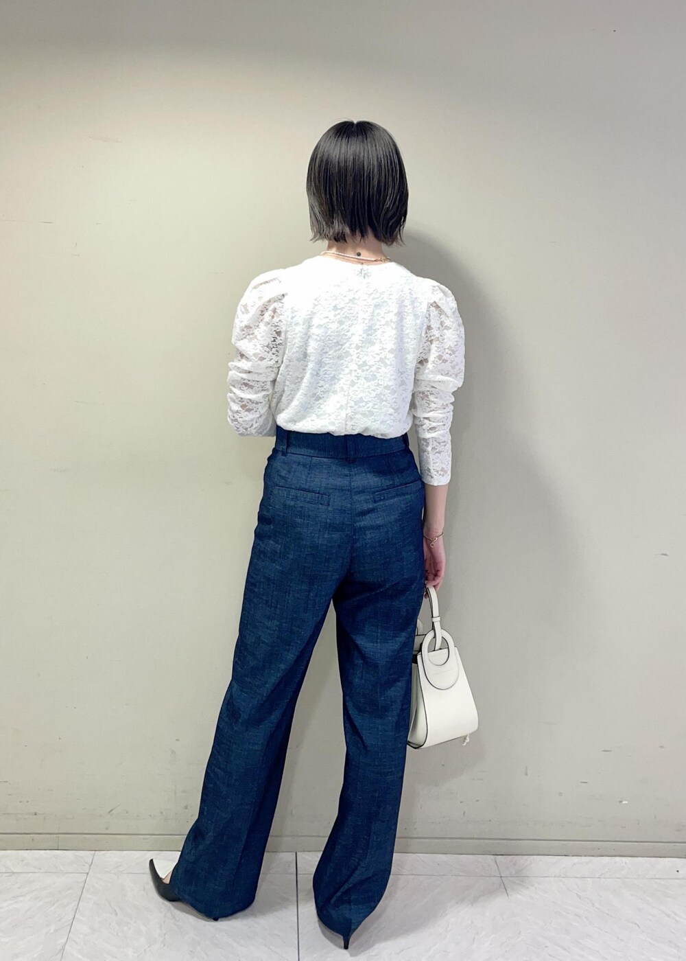 ブラック系のパンプス、イエロー系のカーディガン/ボレロ、ホワイト系のTシャツ/カットソーを着用したレディースの春コーディネートの4枚目の写真