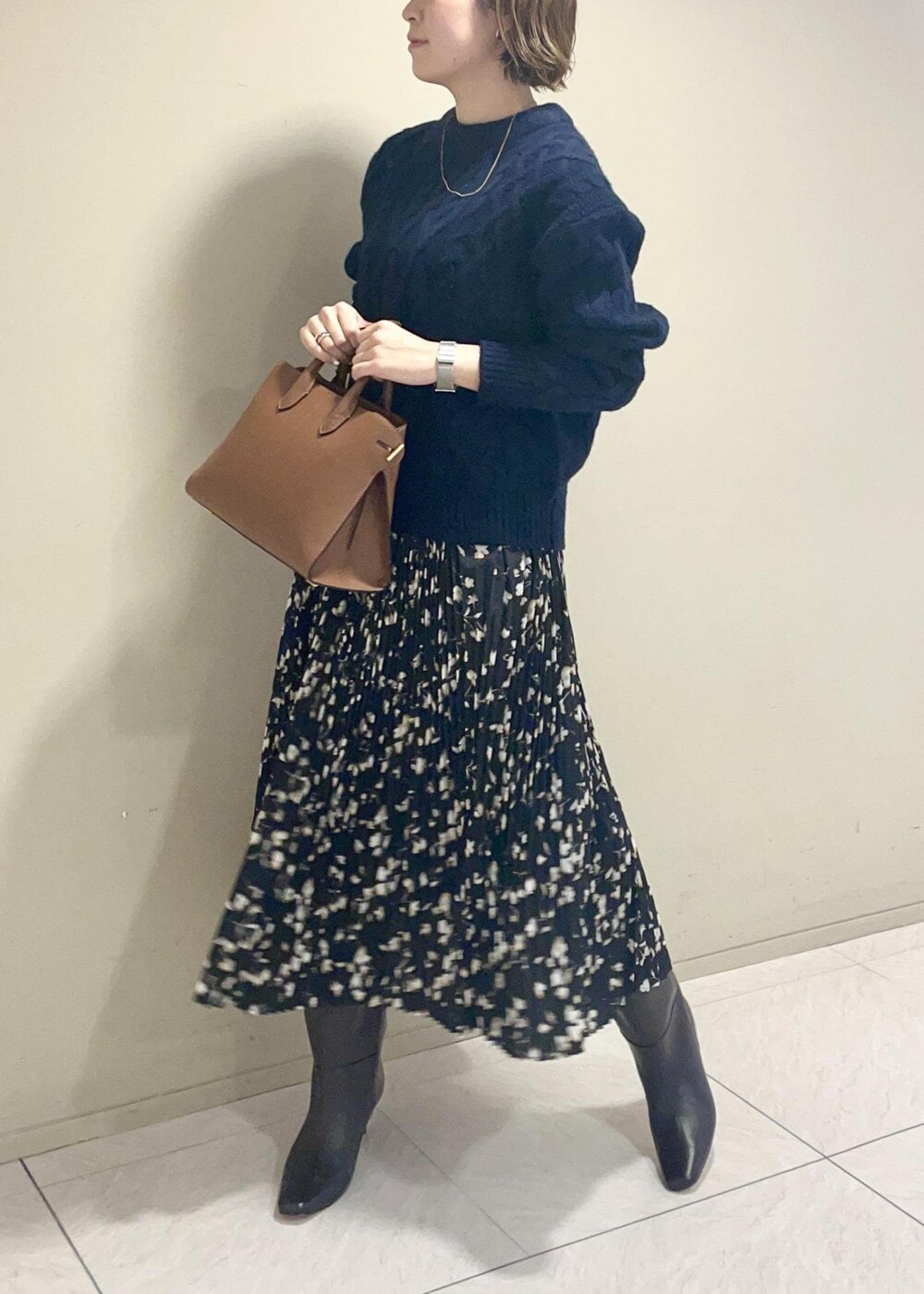 ブラウン系のブーツ、イエロー系のトートバッグ、ブラック系のスカートを着用したレディースの秋コーディネートの2枚目の写真