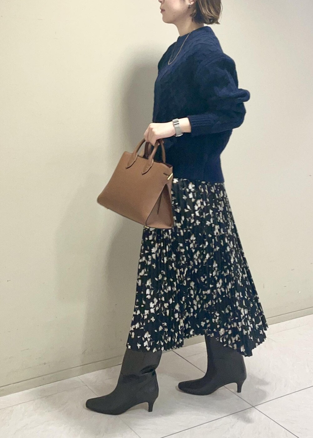 ブラウン系のブーツ、イエロー系のトートバッグ、ブラック系のスカートを着用したレディースの秋コーディネートの4枚目の写真