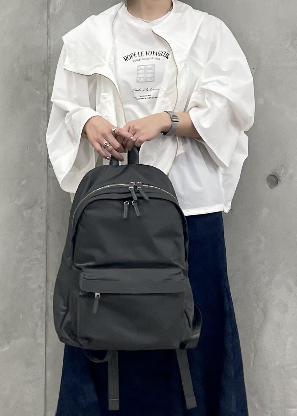 ベージュ系のパンプス、ブルー系のスカート、ホワイト系のマウンテンパーカーを着用したレディースの春コーディネートの8枚目の写真