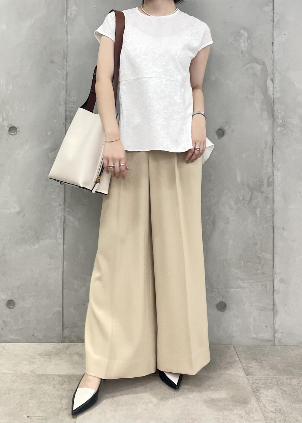 ホワイト系のショルダーバッグ、ブラック系のパンプス、ホワイト系のシャツ/ブラウスを着用したレディースの春コーディネートの3枚目の写真