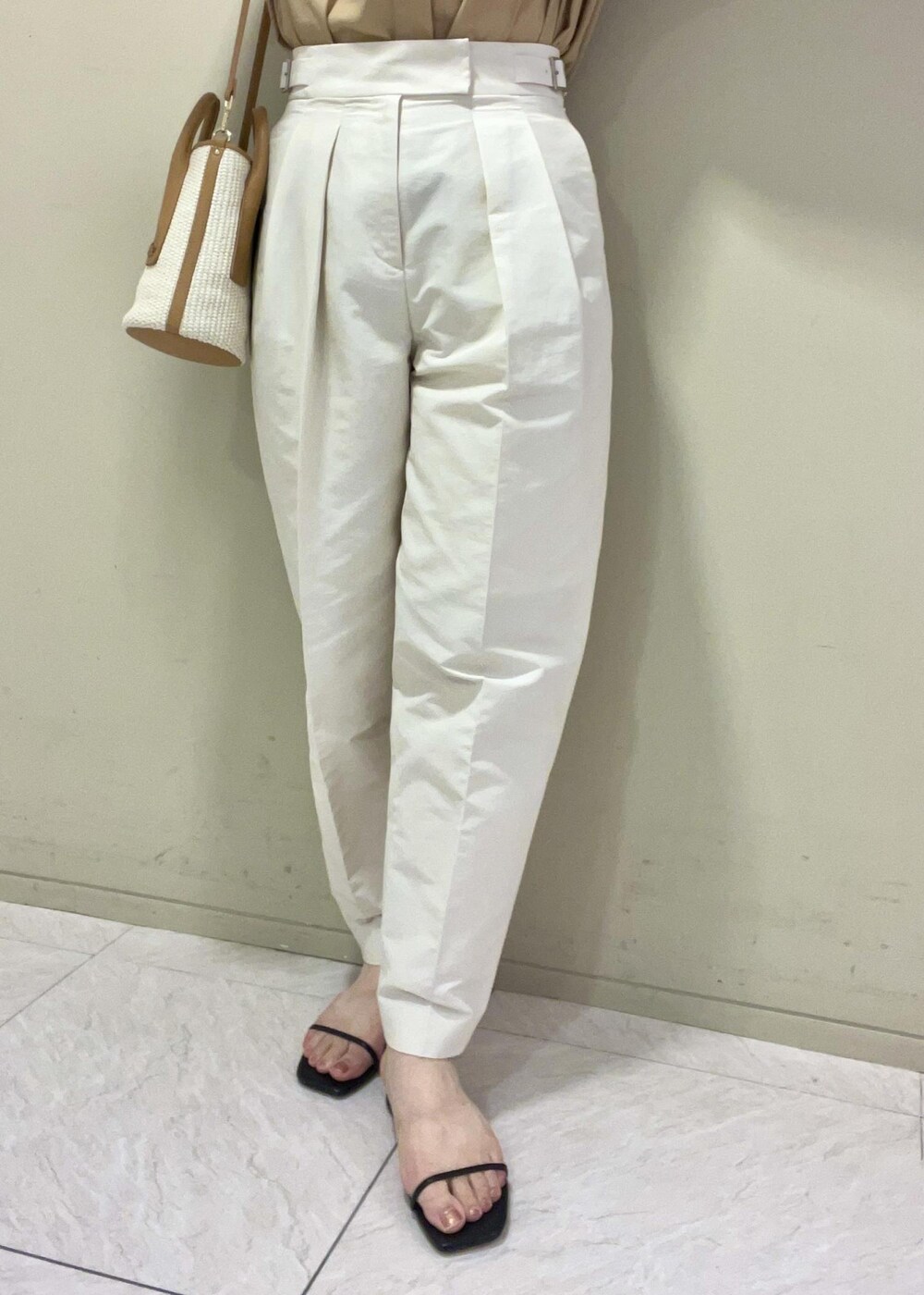 ブラック系のサンダル、ベージュ系のハンドバッグ、ホワイト系のその他パンツを着用したレディースの夏コーディネートの7枚目の写真