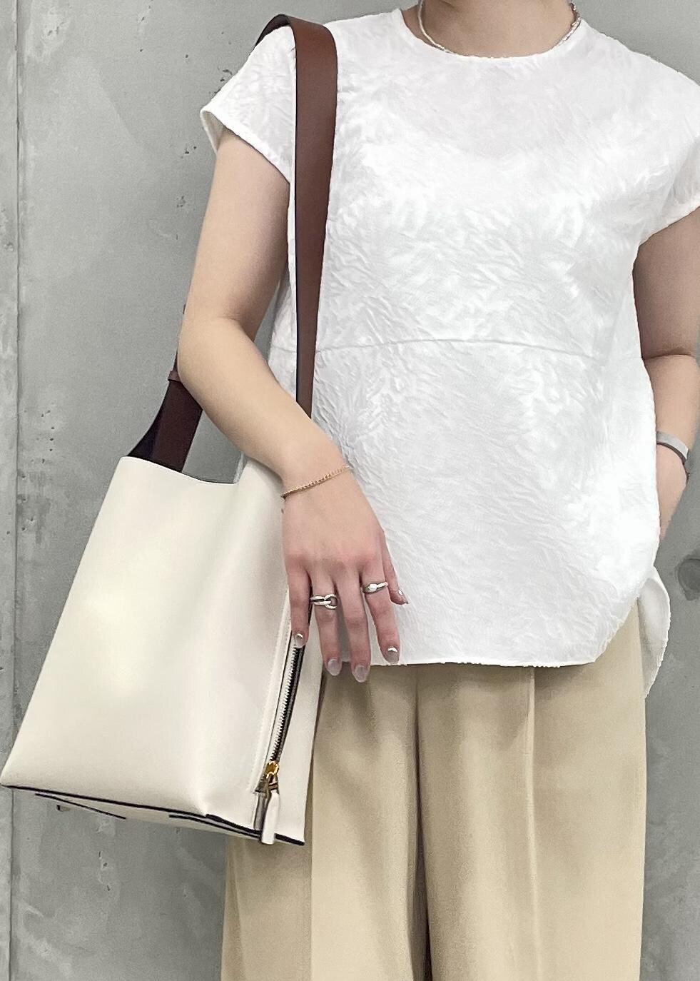 ホワイト系のショルダーバッグ、ブラック系のパンプス、ホワイト系のシャツ/ブラウスを着用したレディースの春コーディネートの6枚目の写真