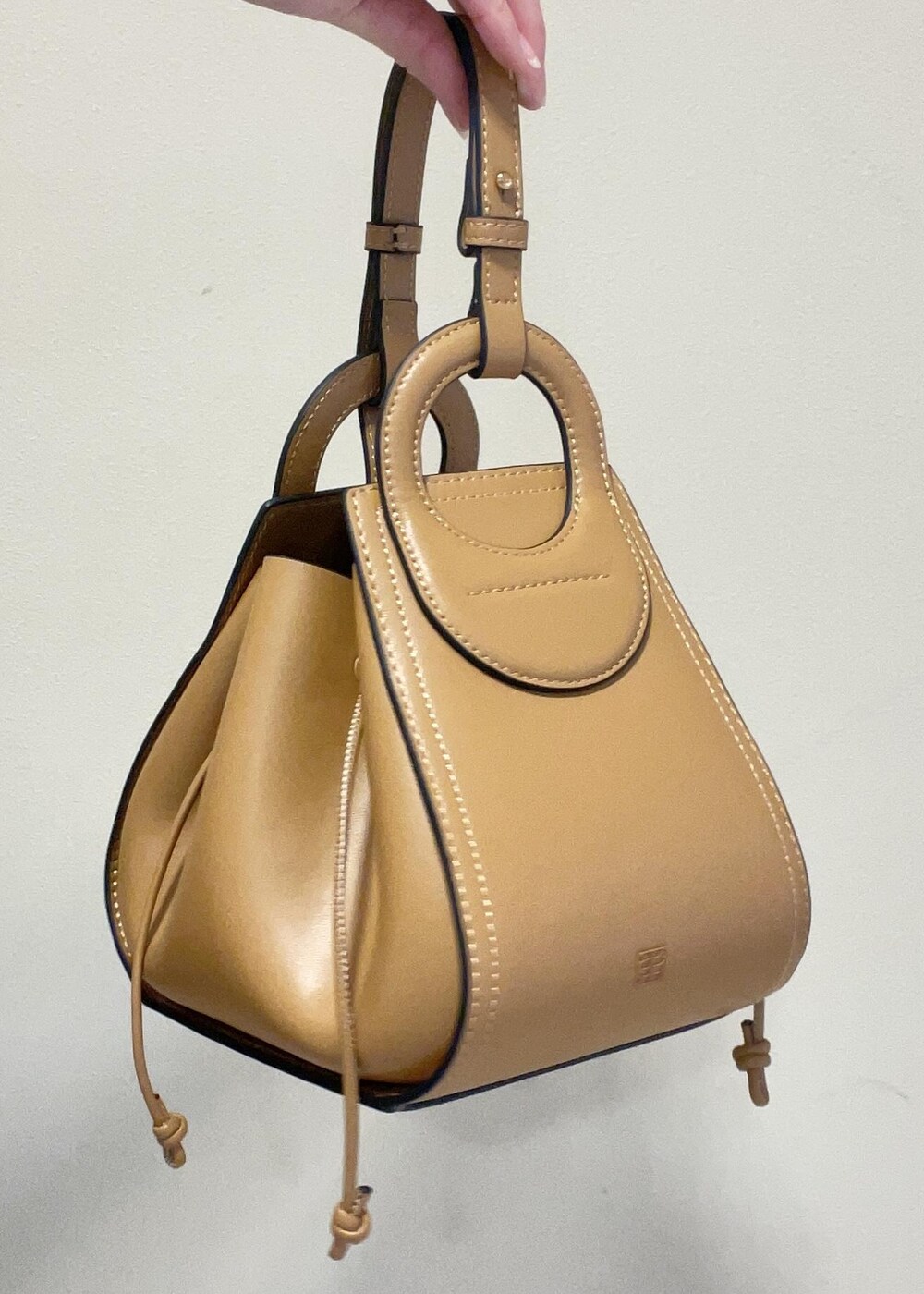 イエロー系のショルダーバッグ、ブルー系のスカート、ブラック系のパンプスを着用したレディースの冬コーディネートの10枚目の写真