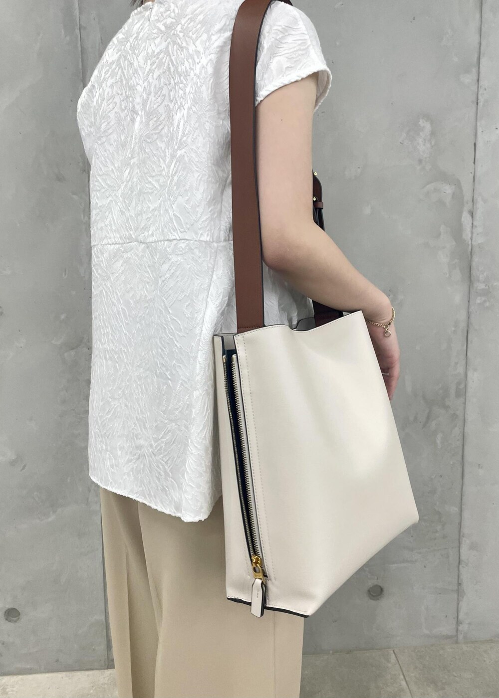 ホワイト系のショルダーバッグ、ブラック系のパンプス、ホワイト系のシャツ/ブラウスを着用したレディースの春コーディネートの9枚目の写真