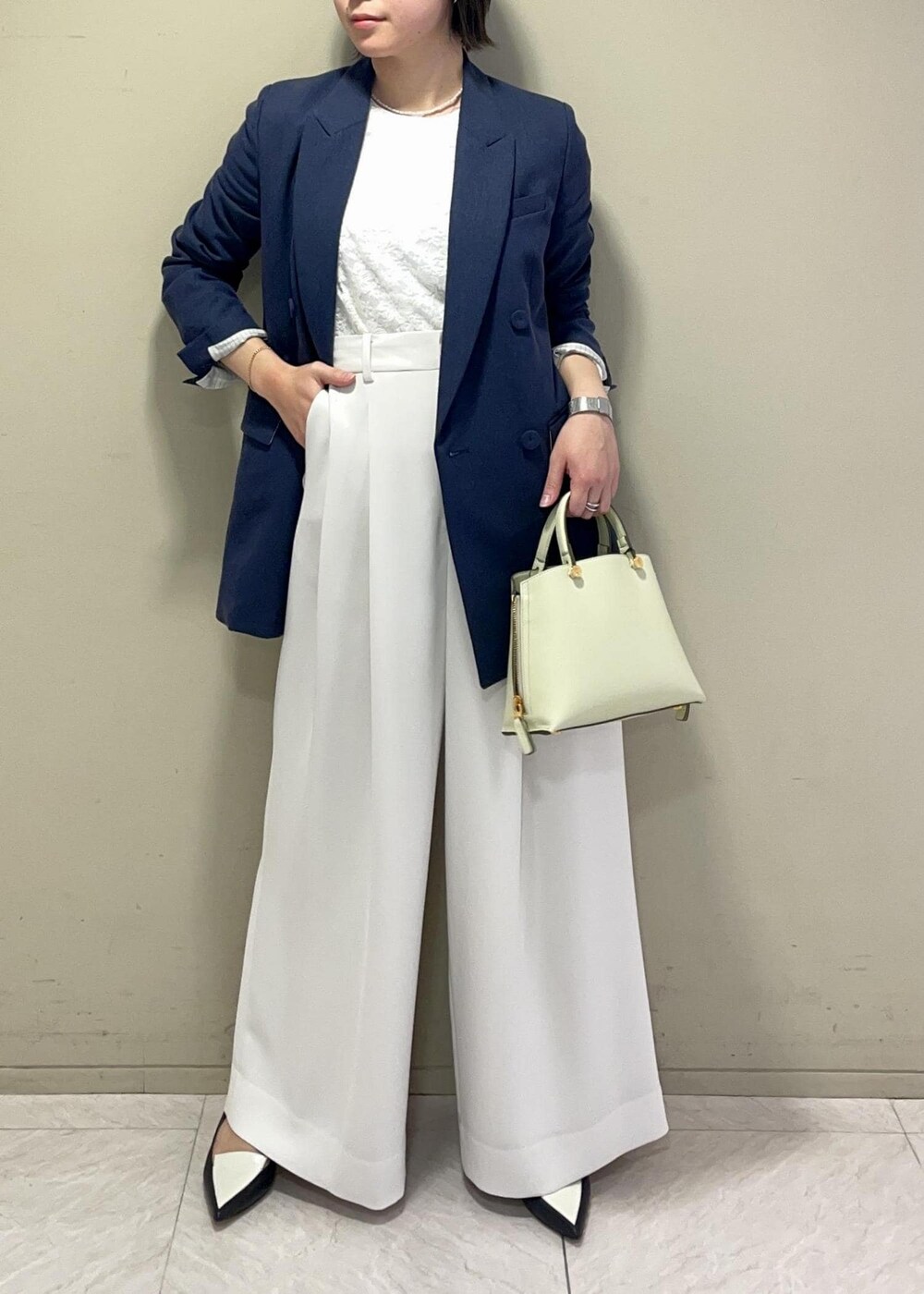 ホワイト系のその他パンツ、グリーン系のハンドバッグ、ブラック系のパンプスを着用したレディースの春コーディネートの3枚目の写真