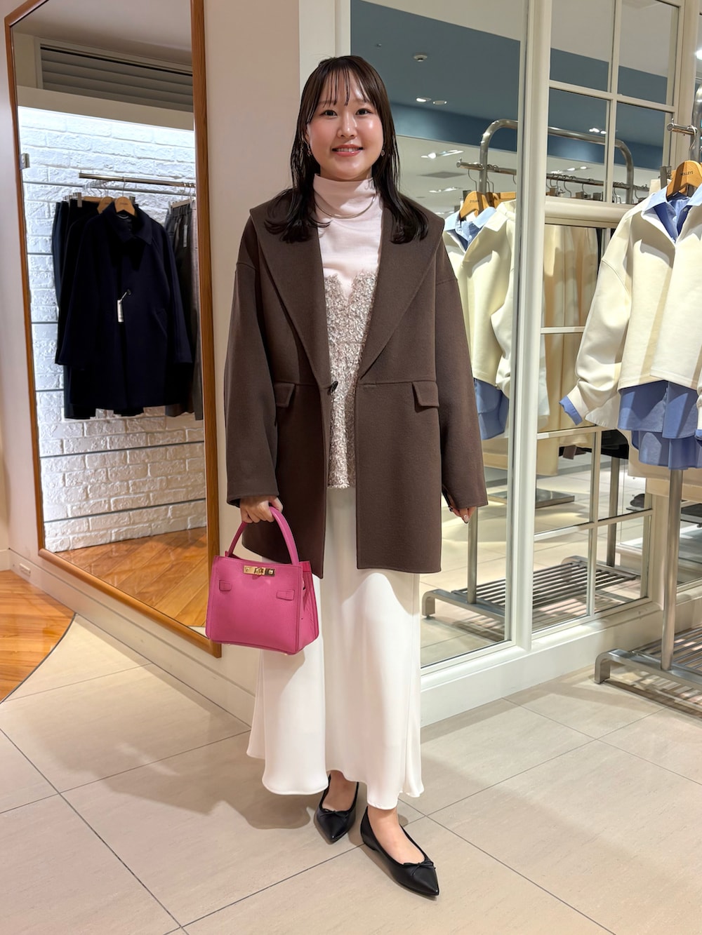 ベージュ系のキャミソール、ピンク系のニット/セーター、ホワイト系のスカートを着用したレディースの秋コーディネートの5枚目の写真