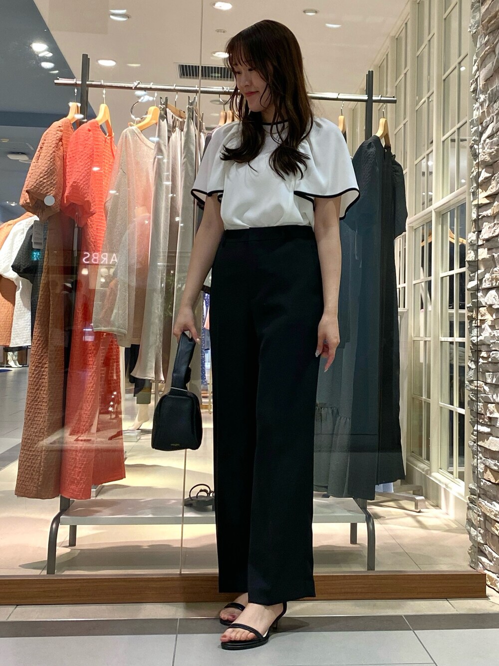 ベージュ系のその他パンツ、ブラック系のショルダーバッグ、ホワイト系のシャツ/ブラウスを着用したレディースの春コーディネートの5枚目の写真