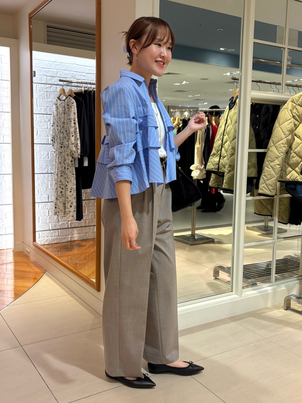 ブラウン系のその他パンツ、ブルー系のその他トップス、ホワイト系のタンクトップを着用したレディースの秋コーディネートの5枚目の写真