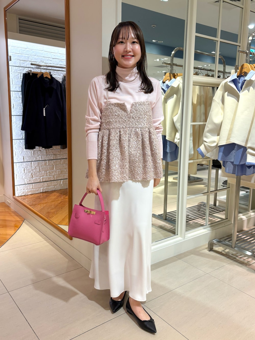 ブラック系のショルダーバッグ、ベージュ系のキャミソール、ピンク系のニット/セーターを着用したレディースの秋コーディネートの5枚目の写真