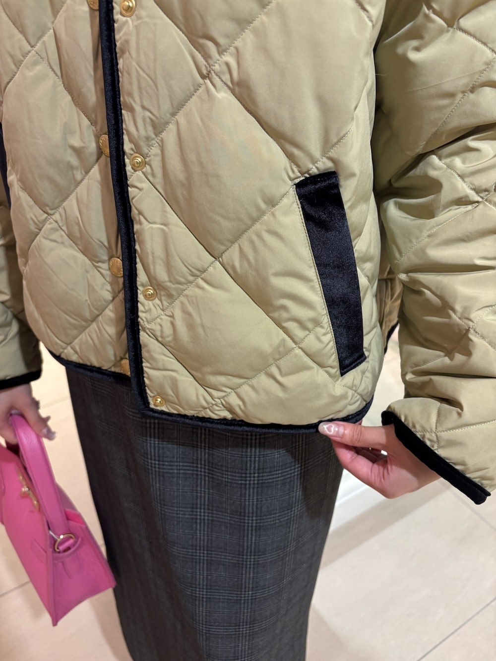 ベージュ系のショルダーバッグ、ベージュ系のダウンジャケット/コート、ブルー系のニット/セーターを着用したレディースの秋コーディネートの5枚目の写真