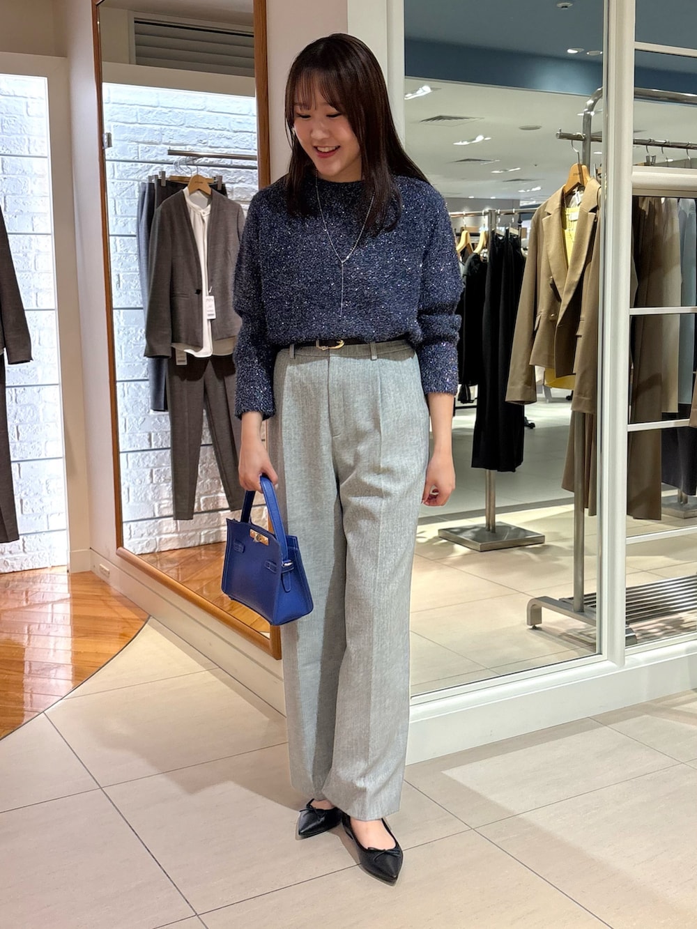 グレー系のその他パンツ、ブルー系のニット/セーター、ブルー系のショルダーバッグを着用したレディースの冬コーディネートの8枚目の写真