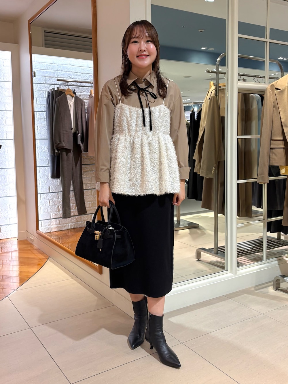 ホワイト系のキャミソール、ブルー系のシャツ/ブラウス、ブラック系のスカートを着用したレディースの冬コーディネートの9枚目の写真