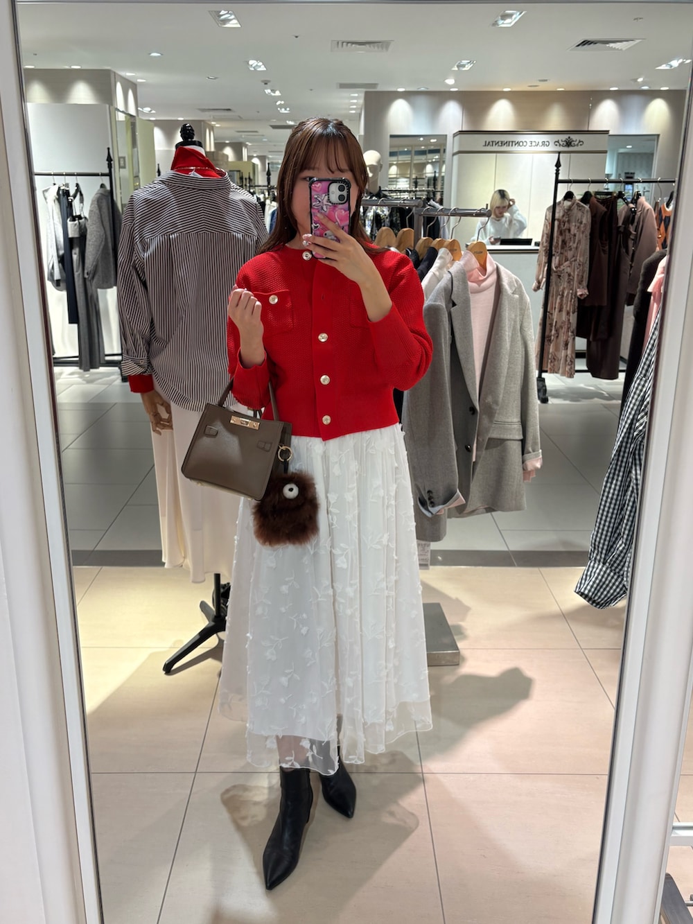 ホワイト系のスカート、レッド系のカーディガン/ボレロ、ベージュ系のショルダーバッグを着用したレディースの秋コーディネートの10枚目の写真