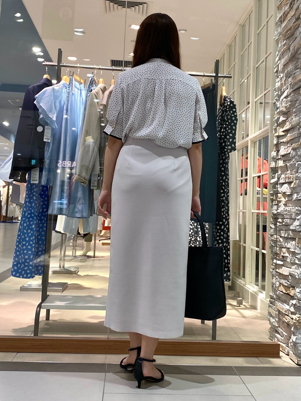 ホワイト系のシャツ/ブラウス、ホワイト系のスカート、ブラック系のトートバッグを着用したレディースの夏コーディネートの3枚目の写真