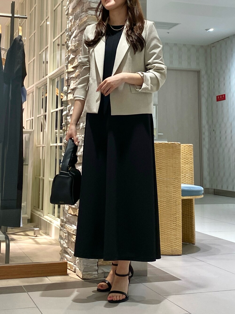 ブラック系のショルダーバッグ、シルバー系のサンダル、ベージュ系のテーラードジャケットを着用したレディースの春コーディネートの3枚目の写真