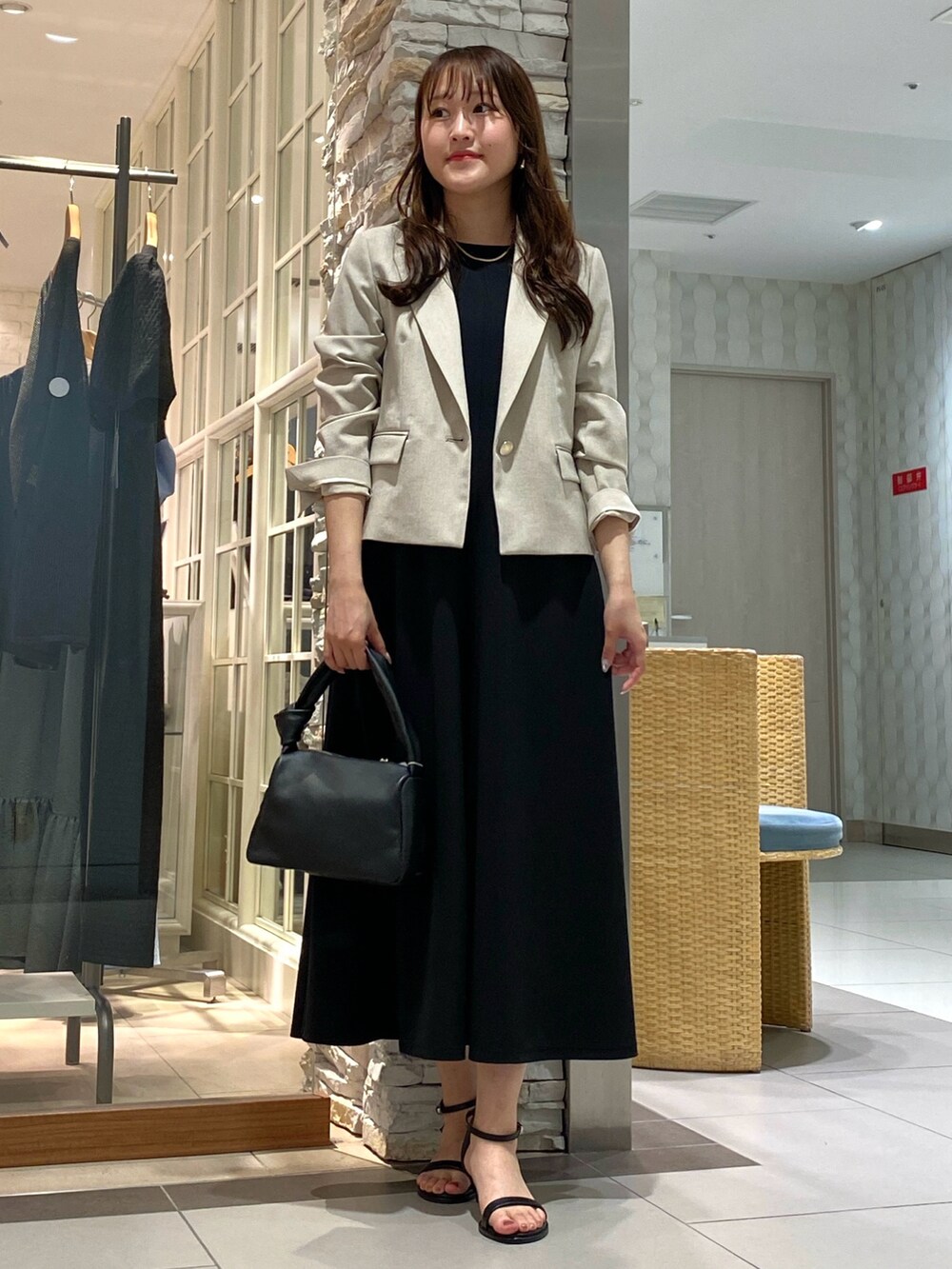 ブラック系のショルダーバッグ、シルバー系のサンダル、ベージュ系のテーラードジャケットを着用したレディースの春コーディネートの2枚目の写真