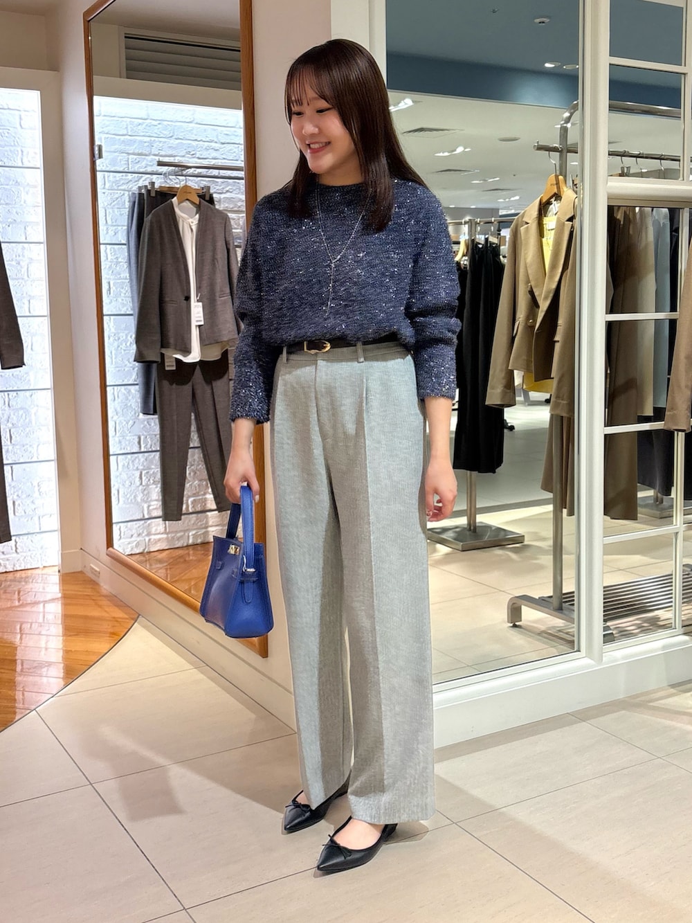 グレー系のその他パンツ、ブルー系のニット/セーター、ブルー系のショルダーバッグを着用したレディースの冬コーディネートの7枚目の写真